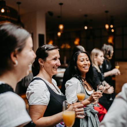 Lächelnde Frauen beim Anstoßen mit Sekt