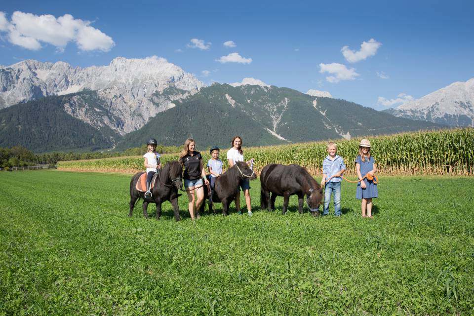 Kinder und 2 Frauen beim Pony Ausritt vor Tiroler Alpen