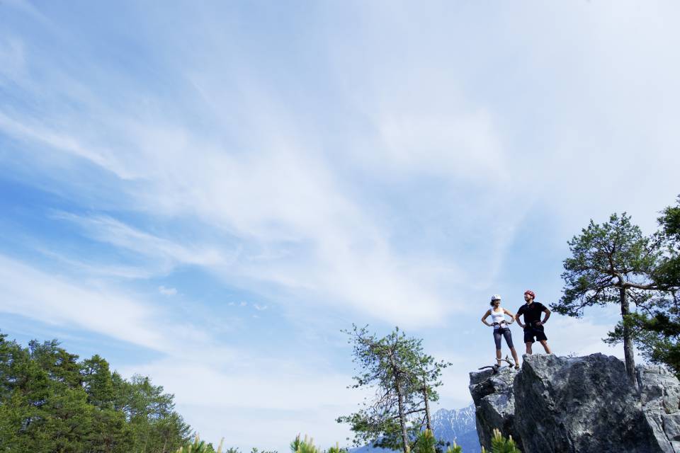 Mann und Frau stehen auf Felsvorsprung in den Tiroler Alpen