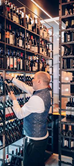 Wein Sommelier im steht im Weinschrank