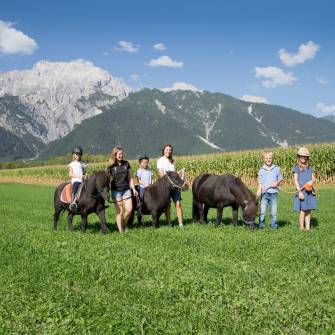 Kinder und 2 Frauen beim Pony Ausritt vor Tiroler Alpen