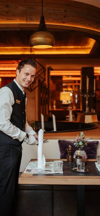 Kellner deckt Tisch ein im Restaurant Alpenresort Schwarz