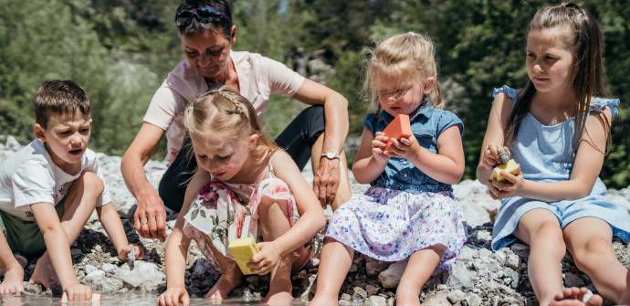 Kinder spielen mit Steinen am Fluss