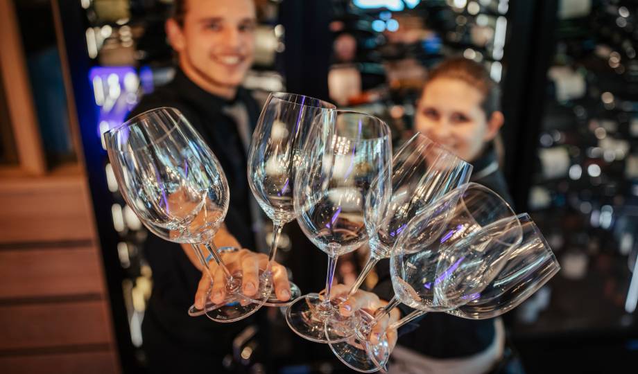 Mitarbeiter des Alpenresort Schwarz halten Weingläser in die Kamera